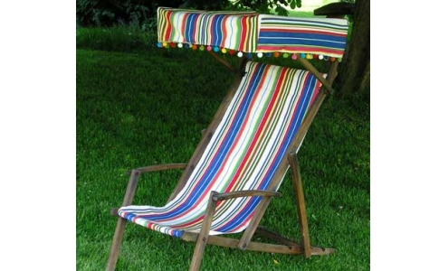 A wooden deck chair with a colorful striped canopy.