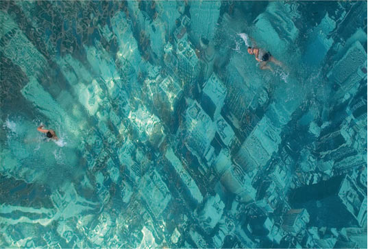 Two people swimming in the water in a city.