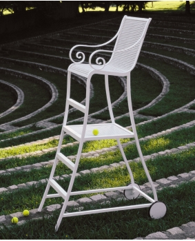 A white wrought iron chair with a tennis ball on it.