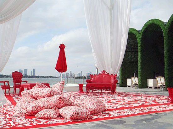 A red and white rug with a white umbrella.