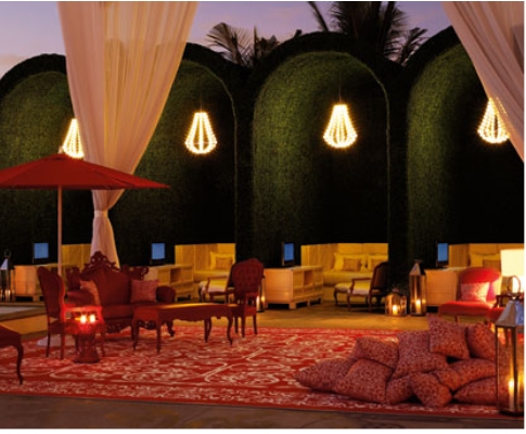 An outdoor area with red furniture and lighting.