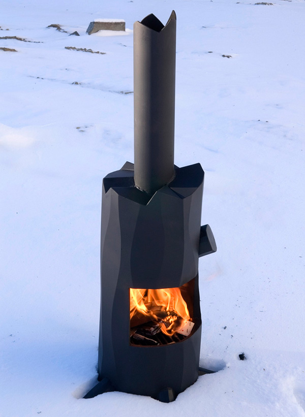 A black wood burning stove sitting in the snow.