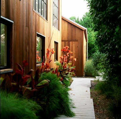 A wooden walkway leads to a wooden house.