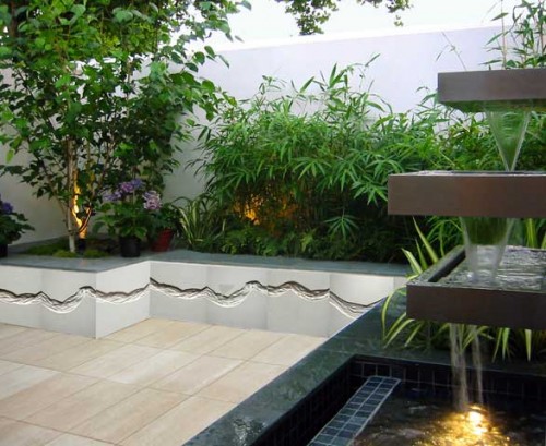 A modern garden with a water feature and plants.