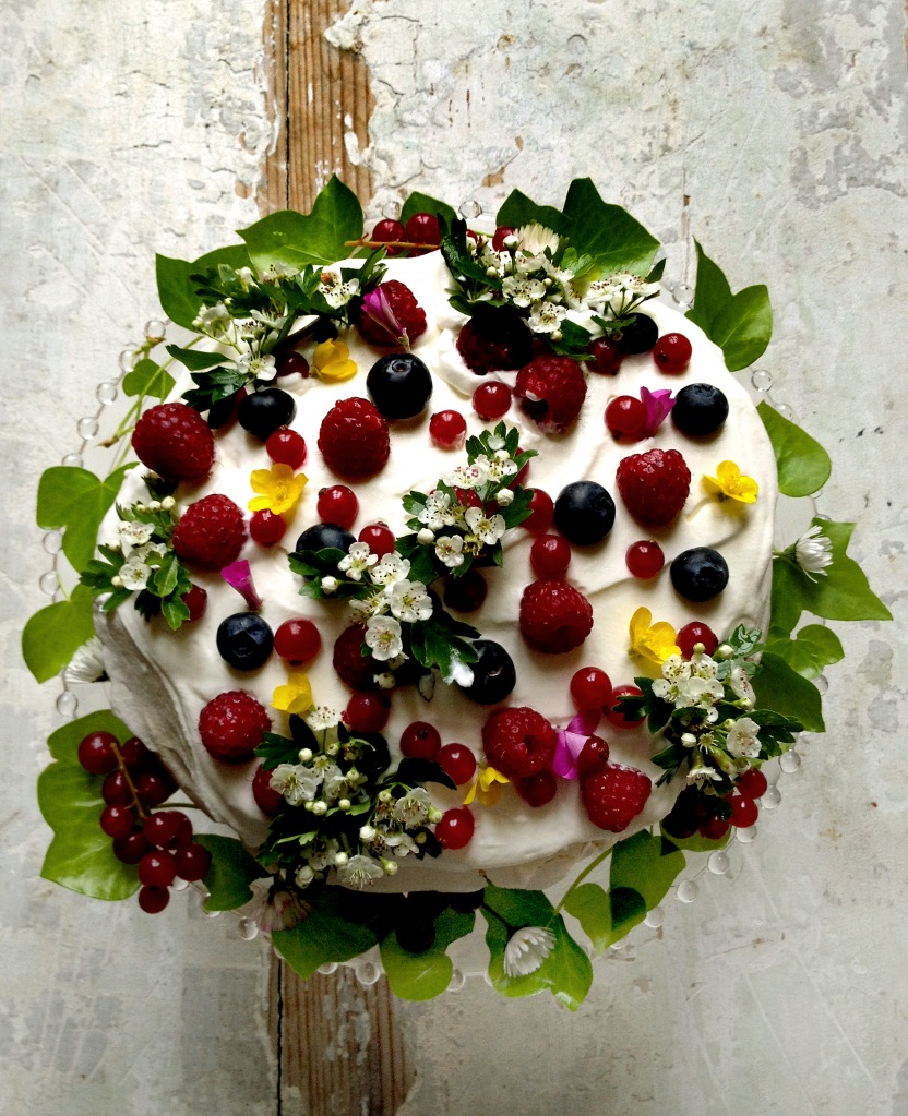 A cake decorated with berries and leaves.