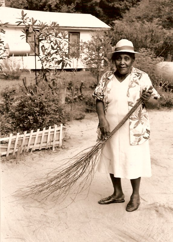 Ms. Waiters demonstrated yard sweeping in the yard of her neighbor, Ms. Cora  Robinson, the only person in the neighborhood who still swept her yard in the 1980s. 