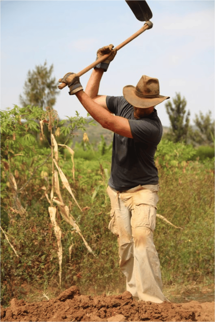 Eddie Dejong is working the soil in Rwanda to assist in building new keyhole garden beds. 
