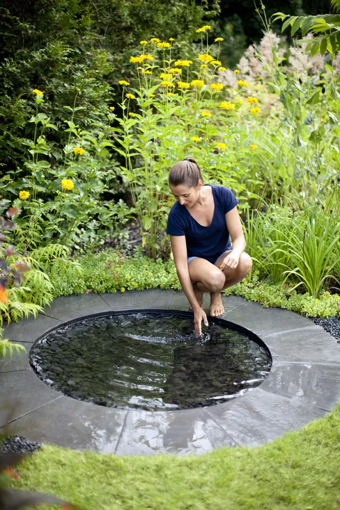 A circular garden water mirror  a reflective surface of still water that creates a mirror-like effect.