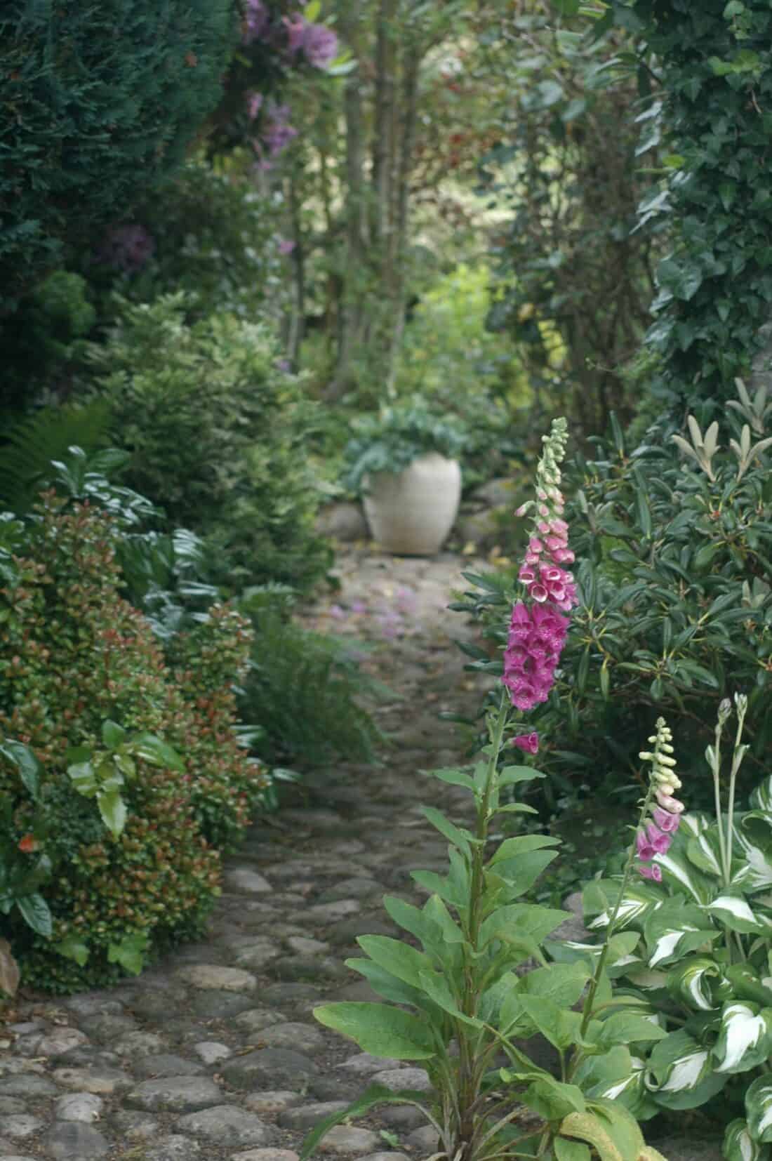 a pretty garden path with a planter focal point at the end
