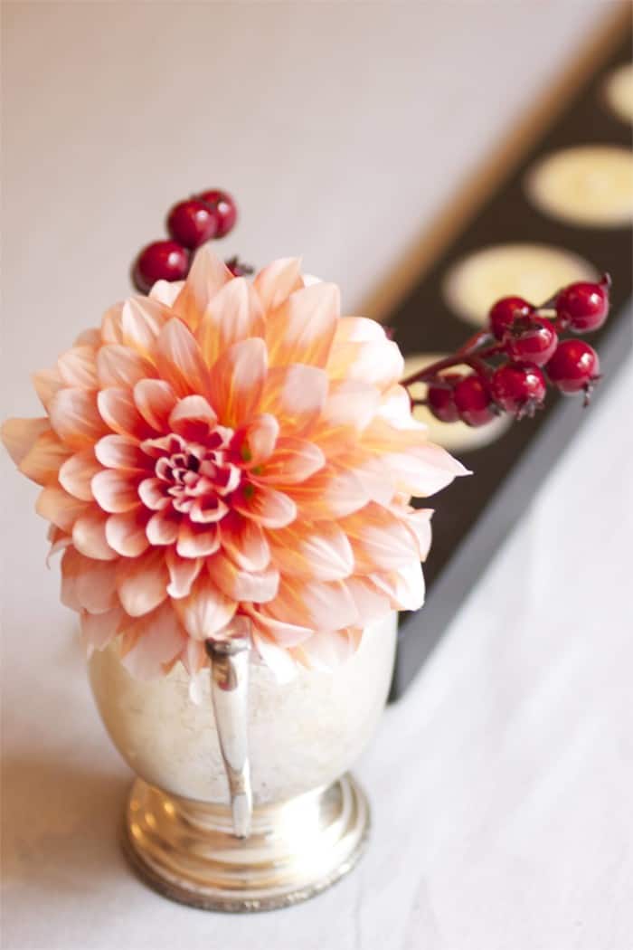 Dahlias in a silver vase with berries.