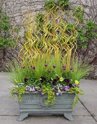 A planter filled with yellow flowers and grasses.