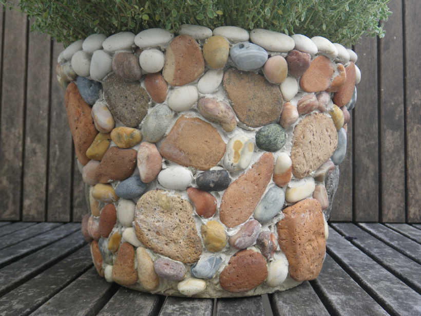 A pot made out of rocks with a plant in it.