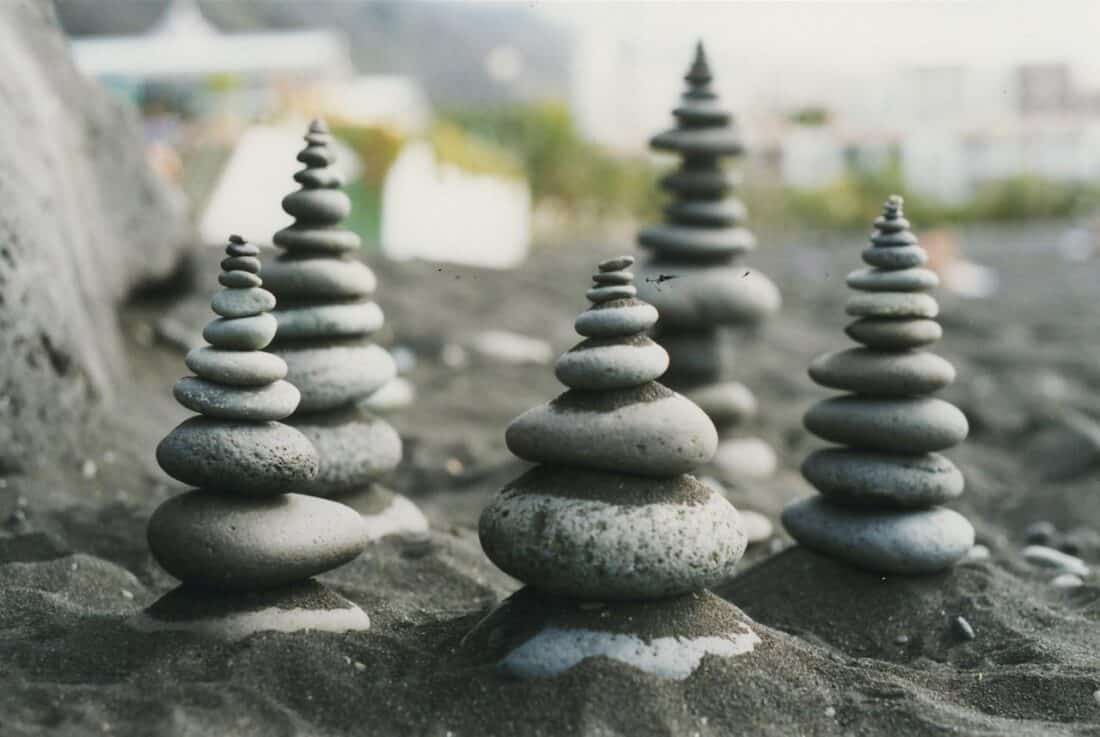 A group of rocks stacked on top of each other in the sand.