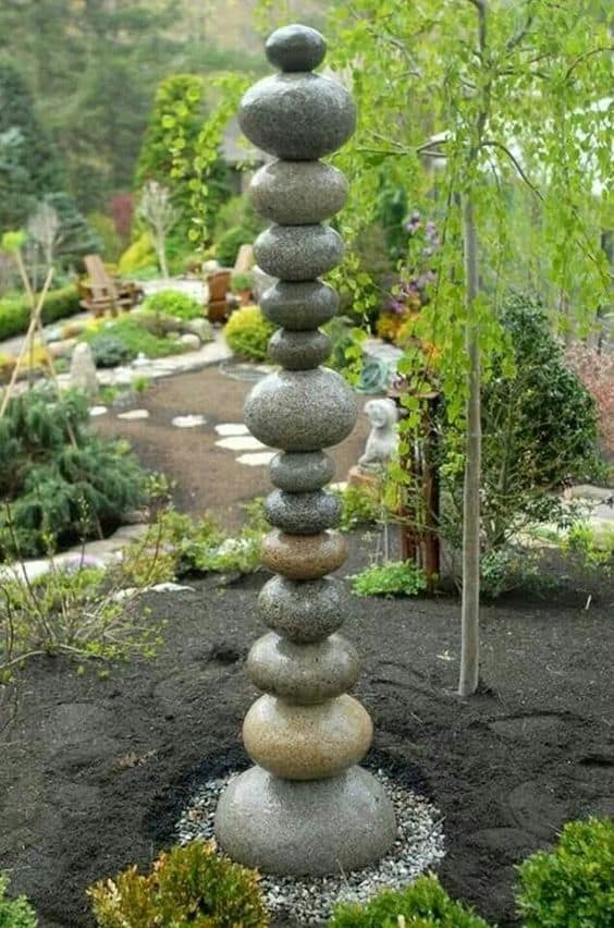 A stacked stone fountain in a garden.
