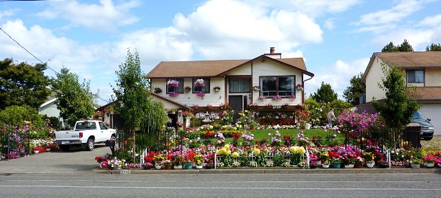 A house with a lot of flowers in front of it.