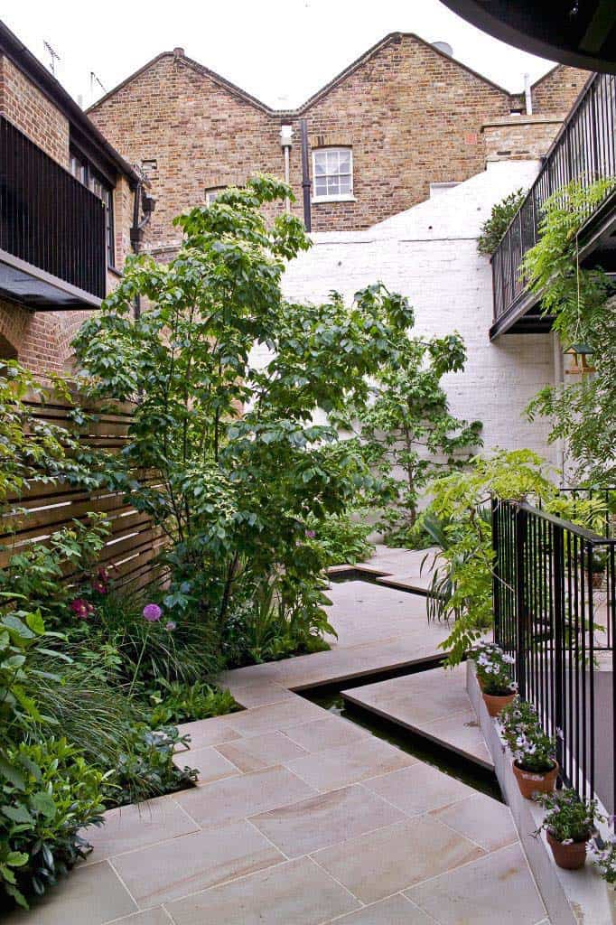 A courtyard with plants and a fence.