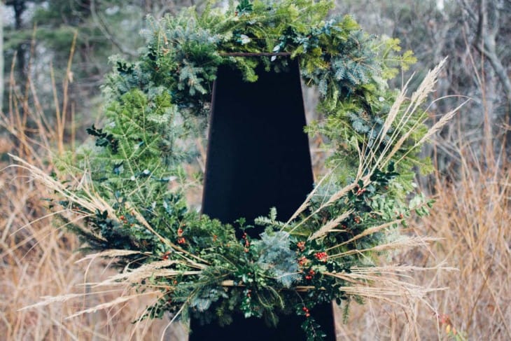 A winter wreath made out of greenery and berries.