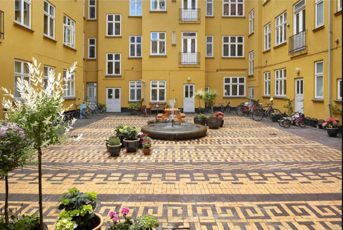 A courtyard in front of a yellow building.