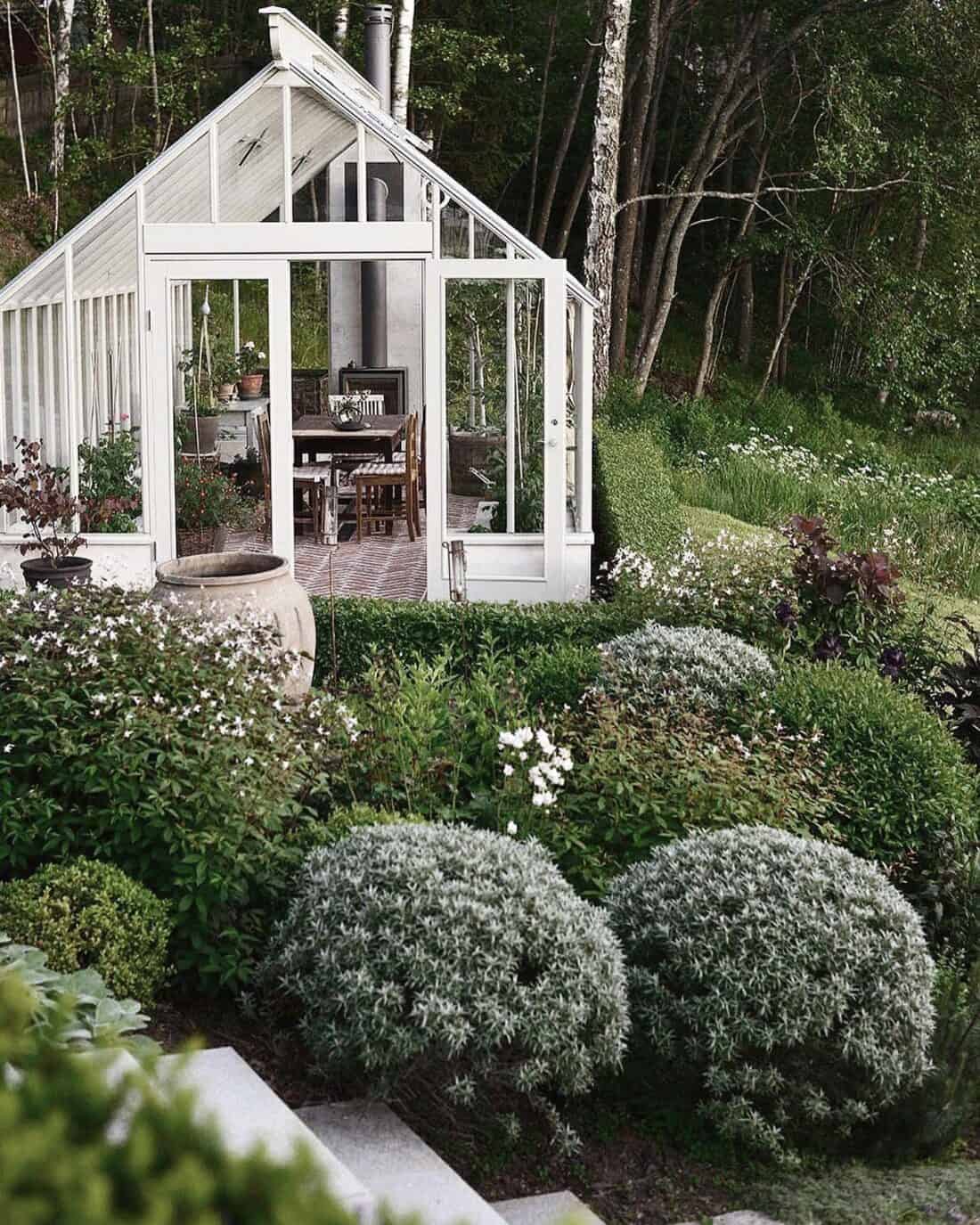 A serene greenhouse nestled amidst an english garden.