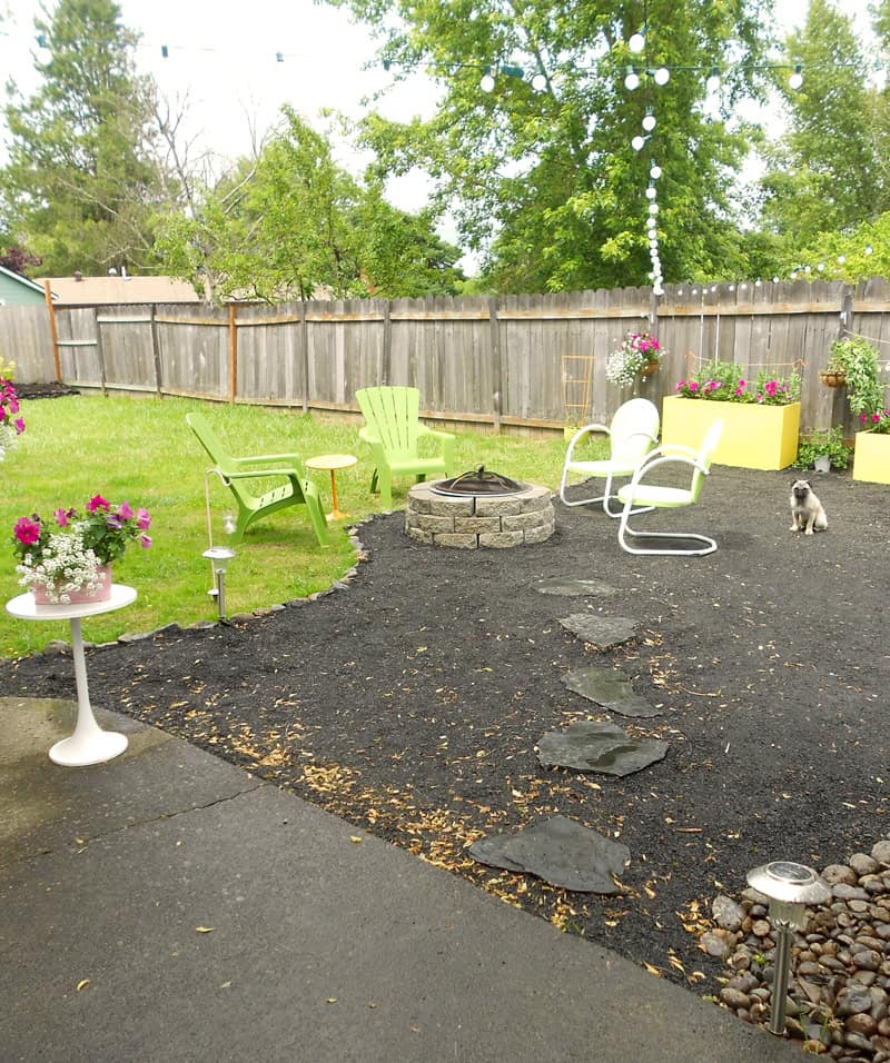 A gravel pation and bright fresh planting in a backyard