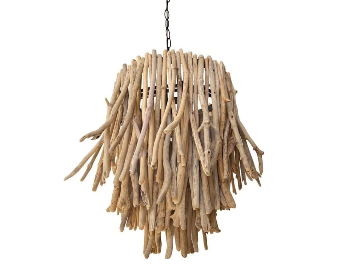 A chandelier made from numerous pieces of driftwood hanging from a black metal chain. The wooden pieces are arranged in a cascading style, creating a rustic, natural appearance. This unique material gives the chandelier a textured and organic look, blending art and functionality.